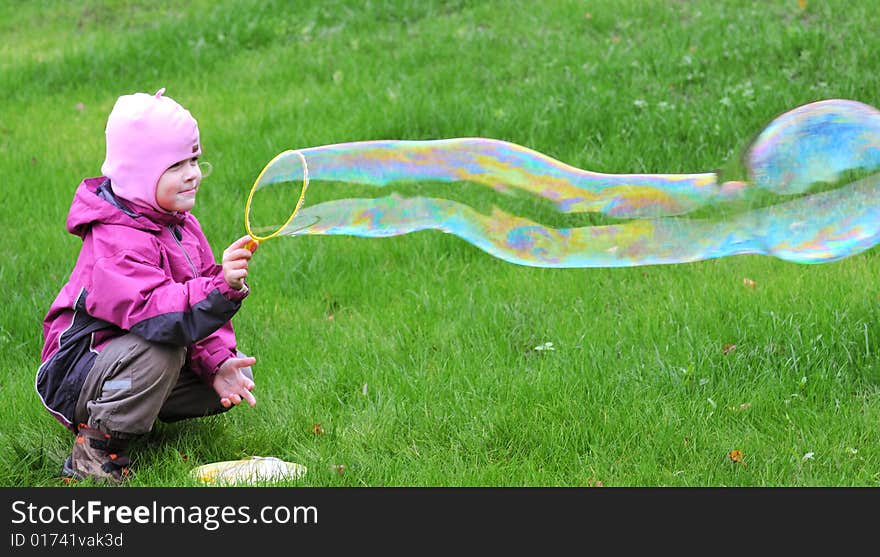 Young girl playing with giant soap bubble. Young girl playing with giant soap bubble