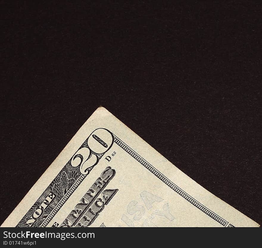 The corner of a twenty dollar bill on a black background. The corner of a twenty dollar bill on a black background.