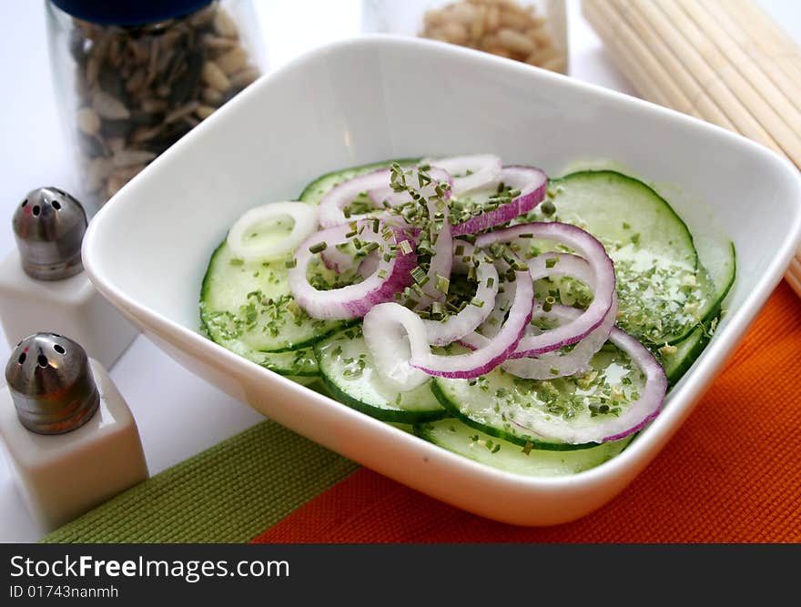 A fresh salad of cucumbers with some red onions