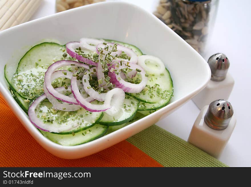 A fresh salad of cucumbers with some red onions