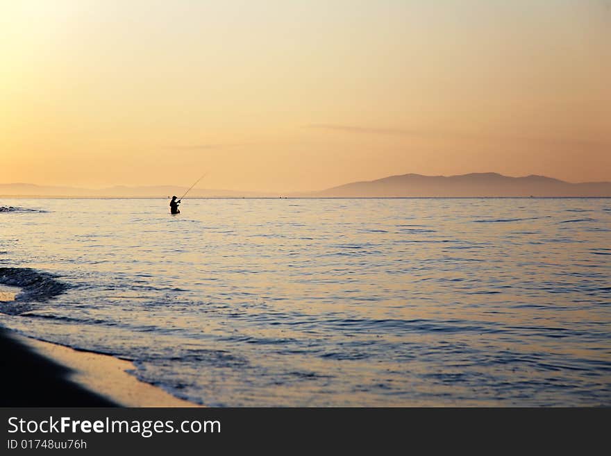 Fisherman silhouette at sunrise, Tuscany, Italy