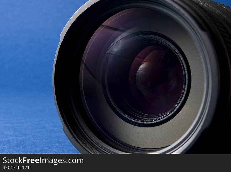 Front elements of a lens on the right-hand side of a blue background providing copy space. Front elements of a lens on the right-hand side of a blue background providing copy space