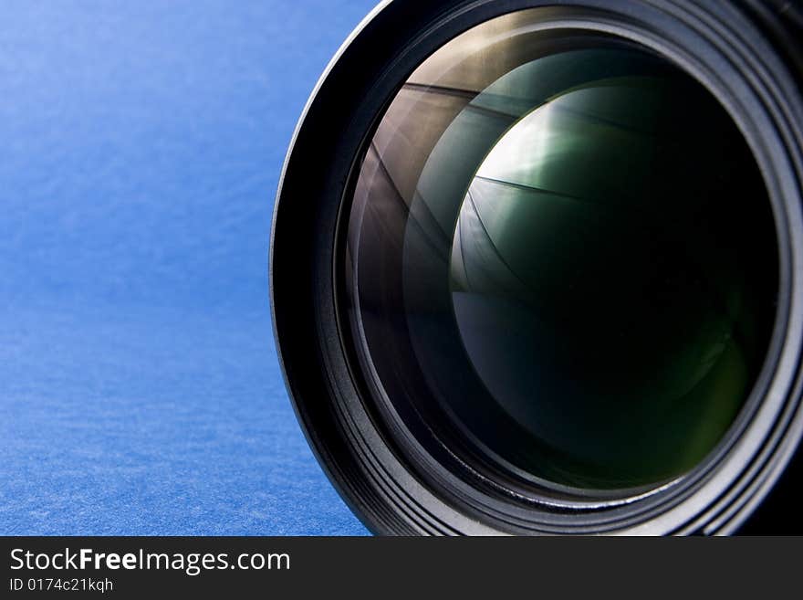 Front elements of a lens on the right-hand side of a blue background providing copy space. Front elements of a lens on the right-hand side of a blue background providing copy space