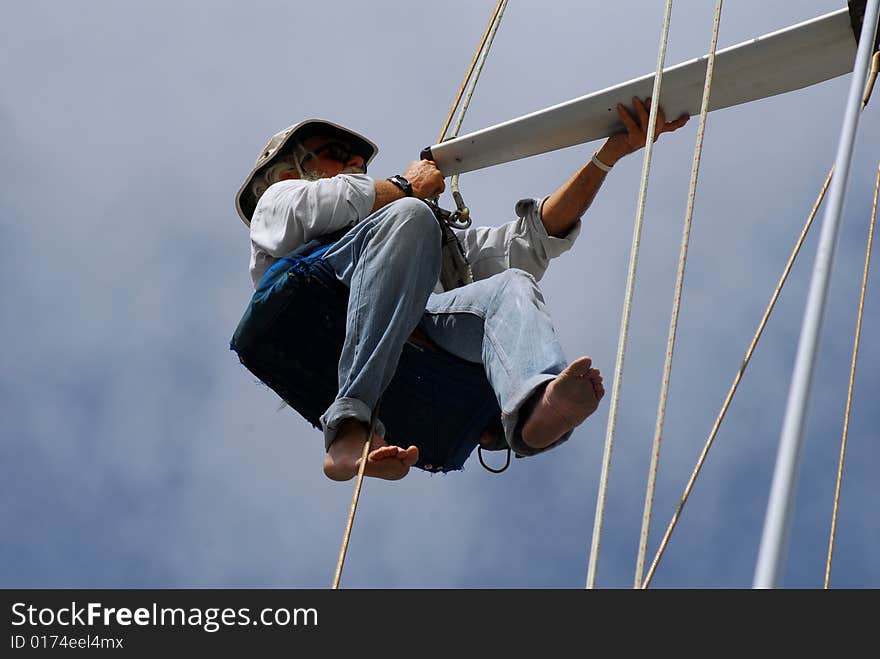 Senior man, marine surveyor, inspecting spreader on sailboat. Senior man, marine surveyor, inspecting spreader on sailboat.