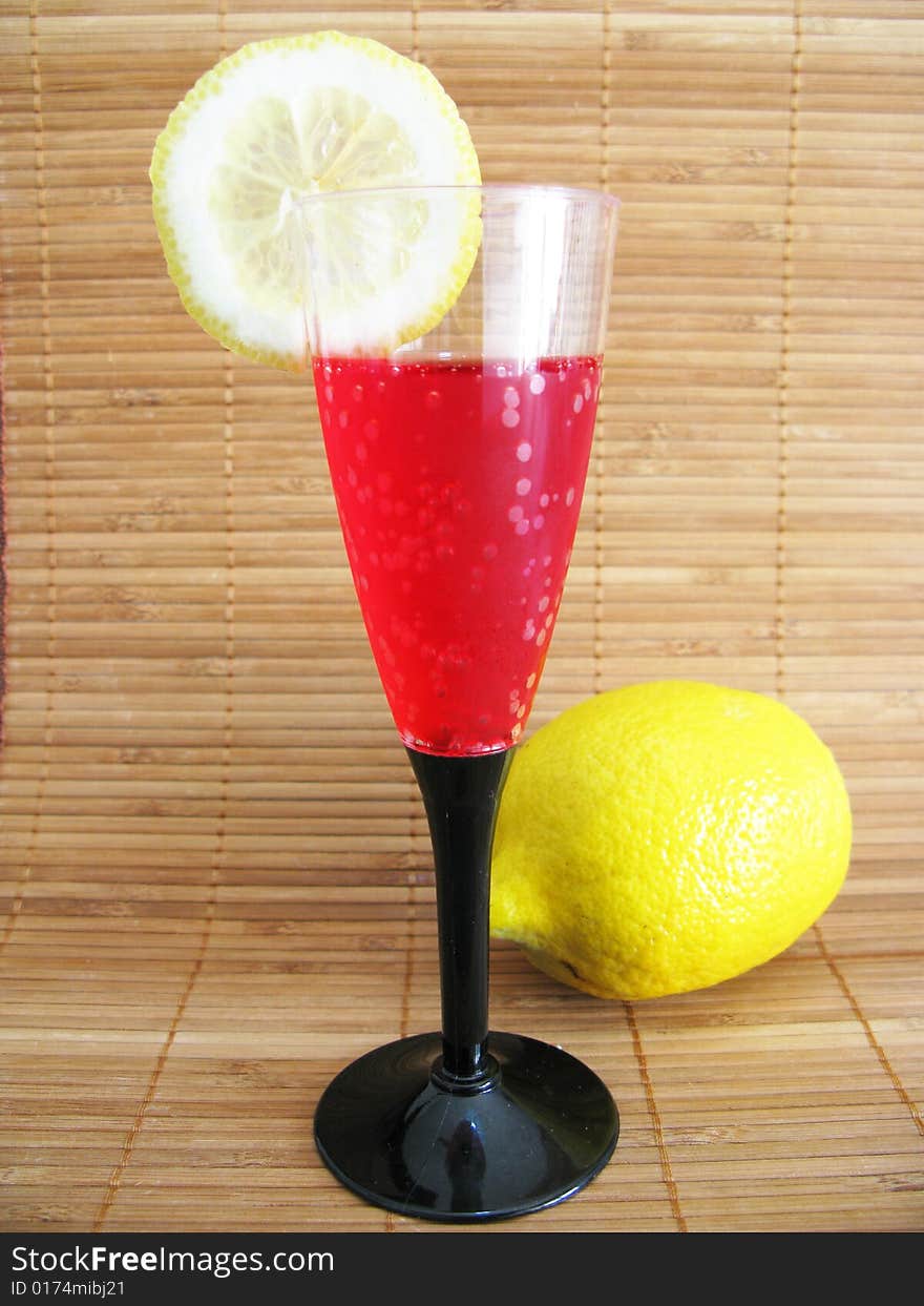Glass with red drink and lemon. Glass with red drink and lemon
