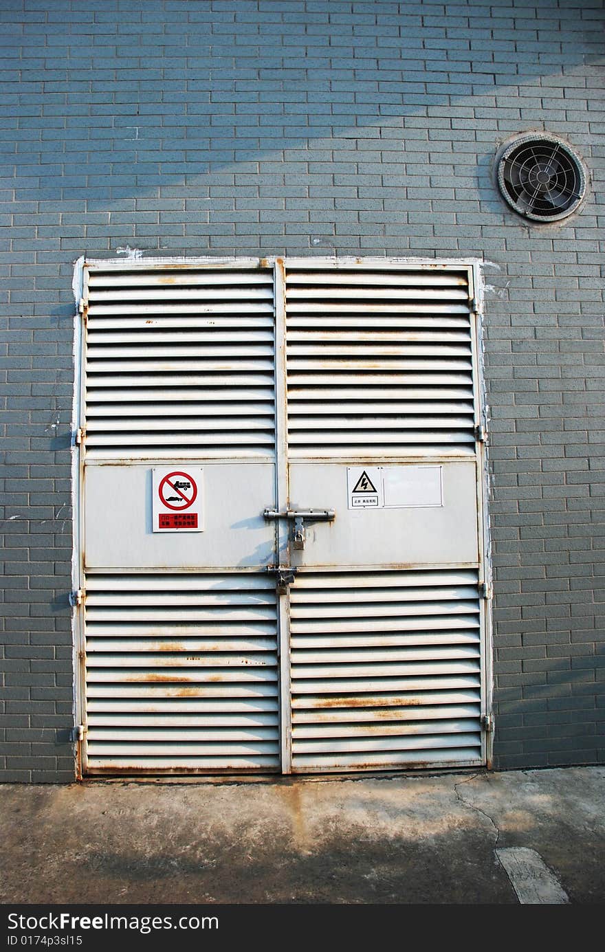 The closed iron door and wall with warning signs of a depositary. The closed iron door and wall with warning signs of a depositary.