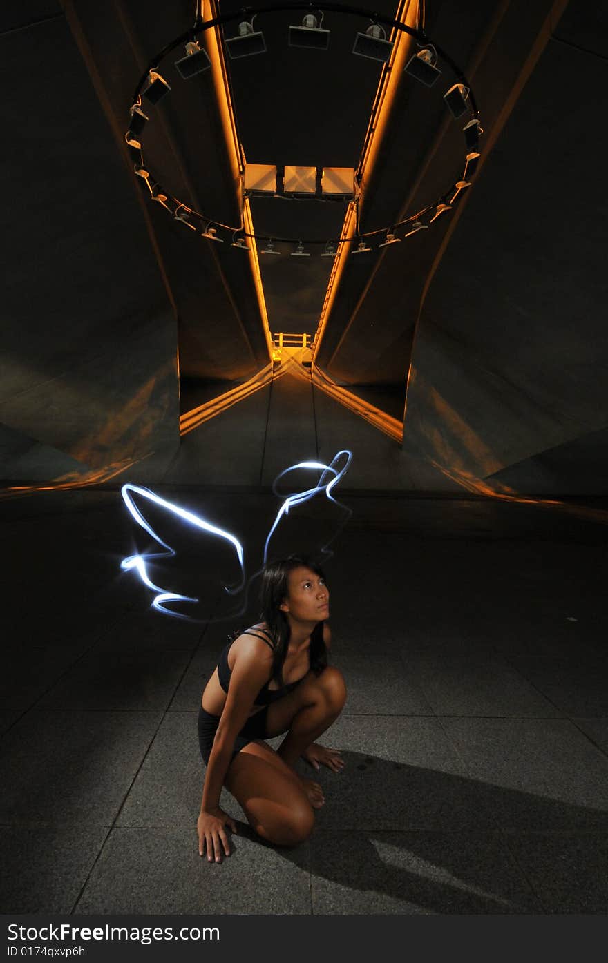 Artistic Picture of a Dancer standing under athletic equipment, painted with light to look like angle wings and halo. Artistic Picture of a Dancer standing under athletic equipment, painted with light to look like angle wings and halo.