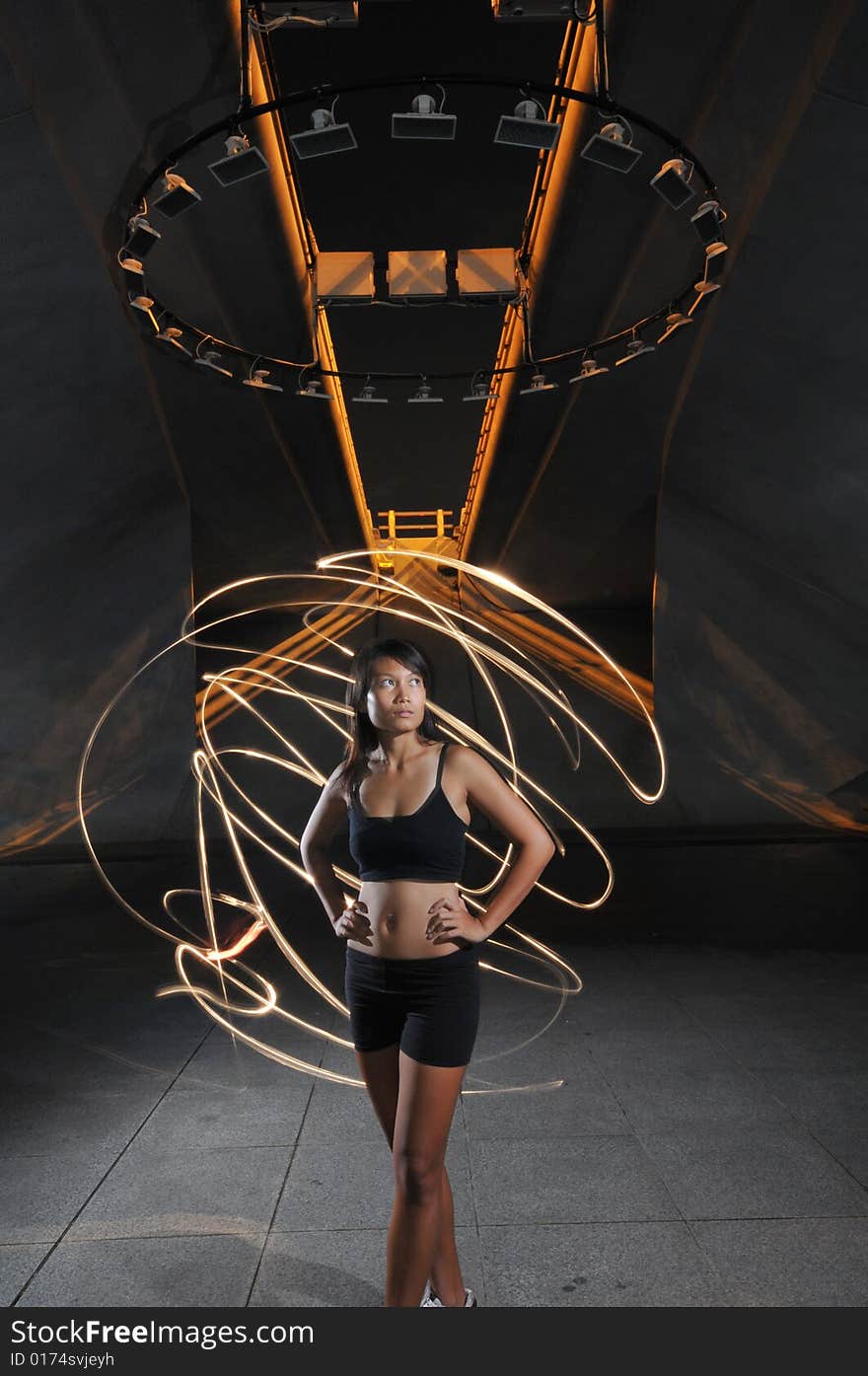 Artistic Picture of a Dancer standing under circle of lights with light painting. Artistic Picture of a Dancer standing under circle of lights with light painting.