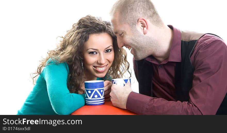 Attractive coupler at home with coffee cups and smiling at each other