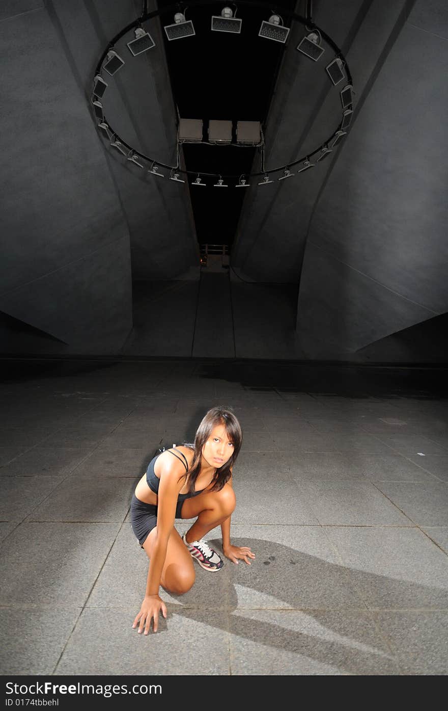 Athletic woman on cement floor underground. Athletic woman on cement floor underground.