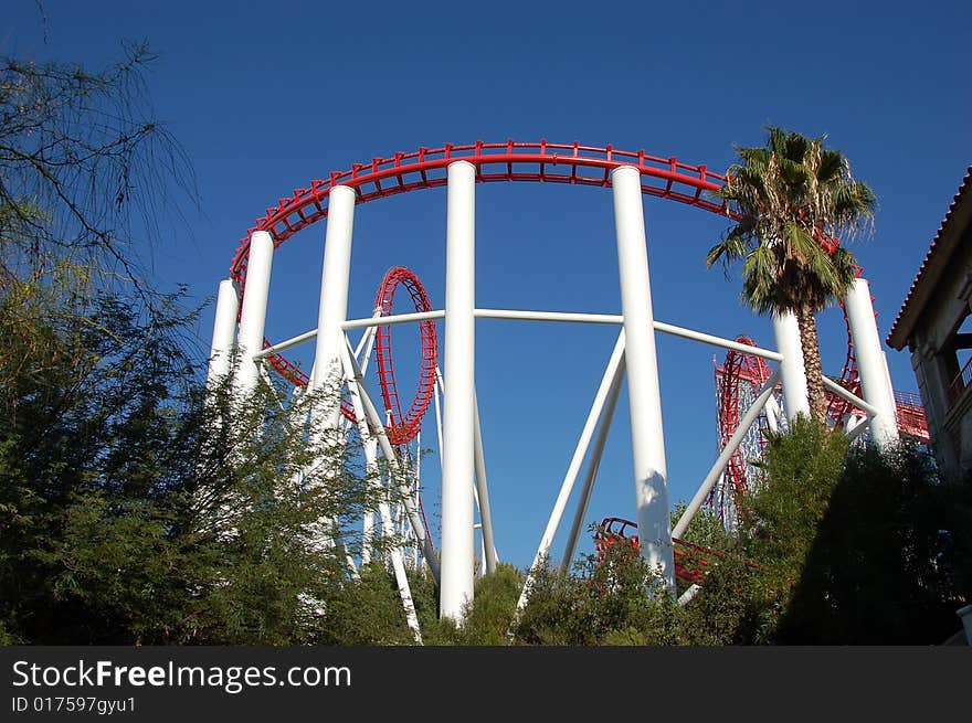 Red and white Rollercoaster against blue sky