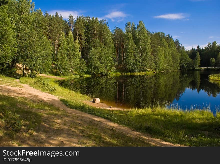 A far pond in the forest with sand bank. A far pond in the forest with sand bank