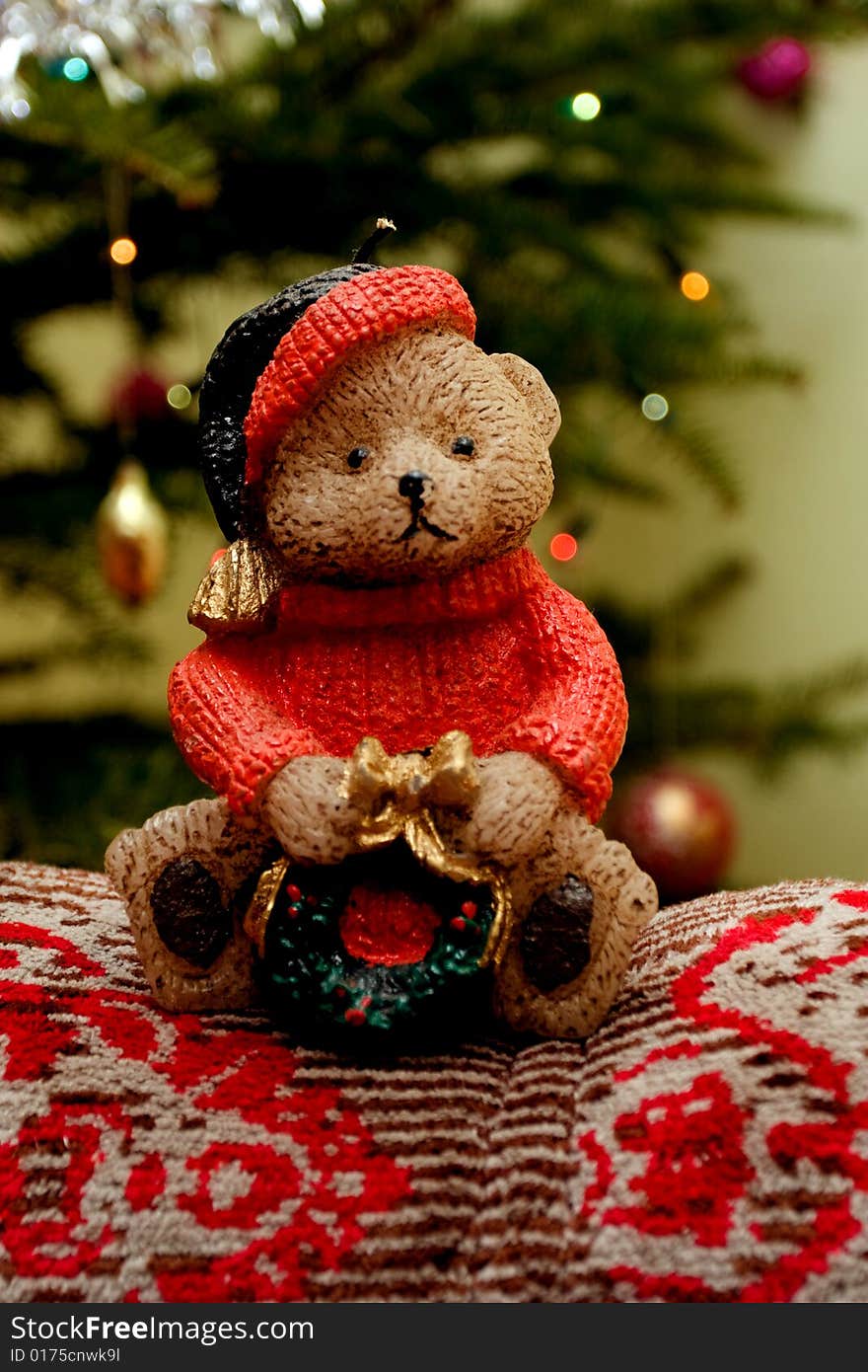 Christmas teddy bear candle near x-mas tree