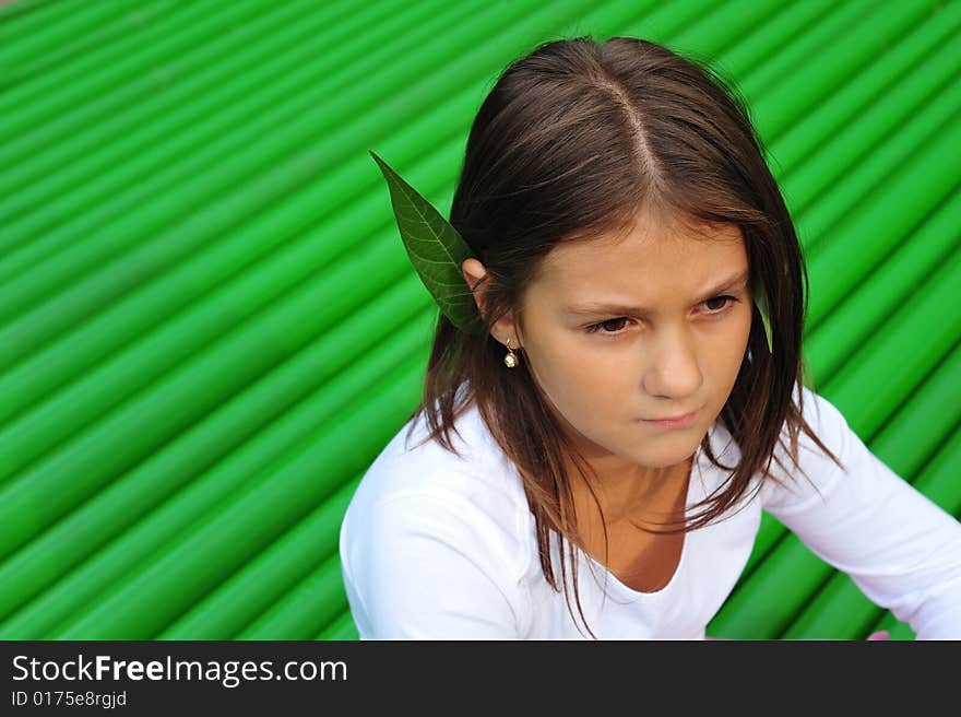 Little girl portrait on green background, close up