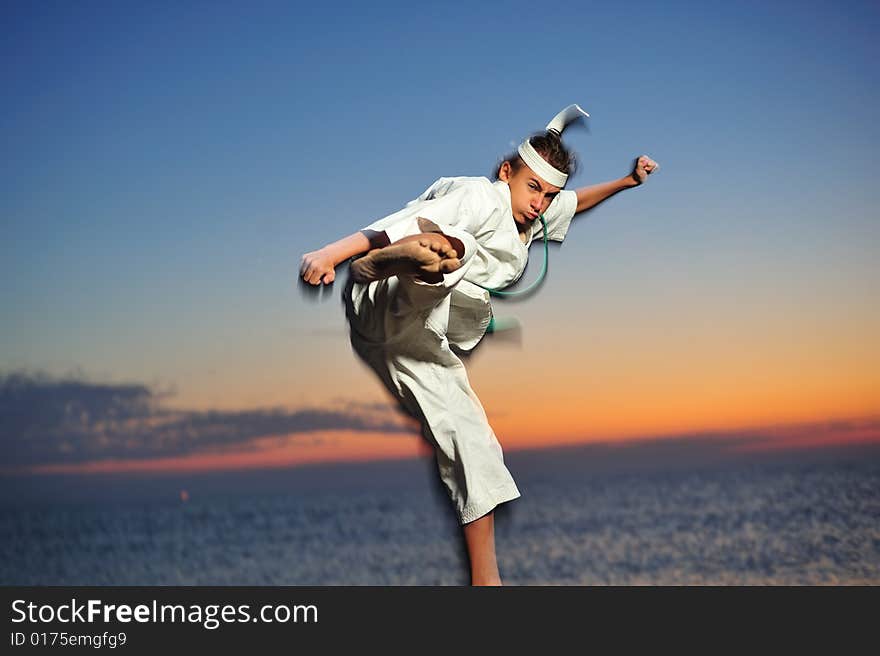 Young boy in karate uniform training at sunset. Young boy in karate uniform training at sunset