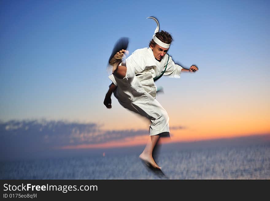 Young boy in karate uniform training at sunset. Young boy in karate uniform training at sunset