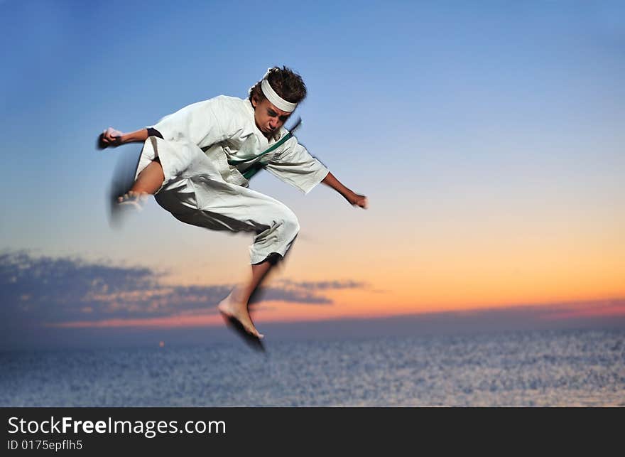 Young boy in karate uniform training at sunset. Young boy in karate uniform training at sunset