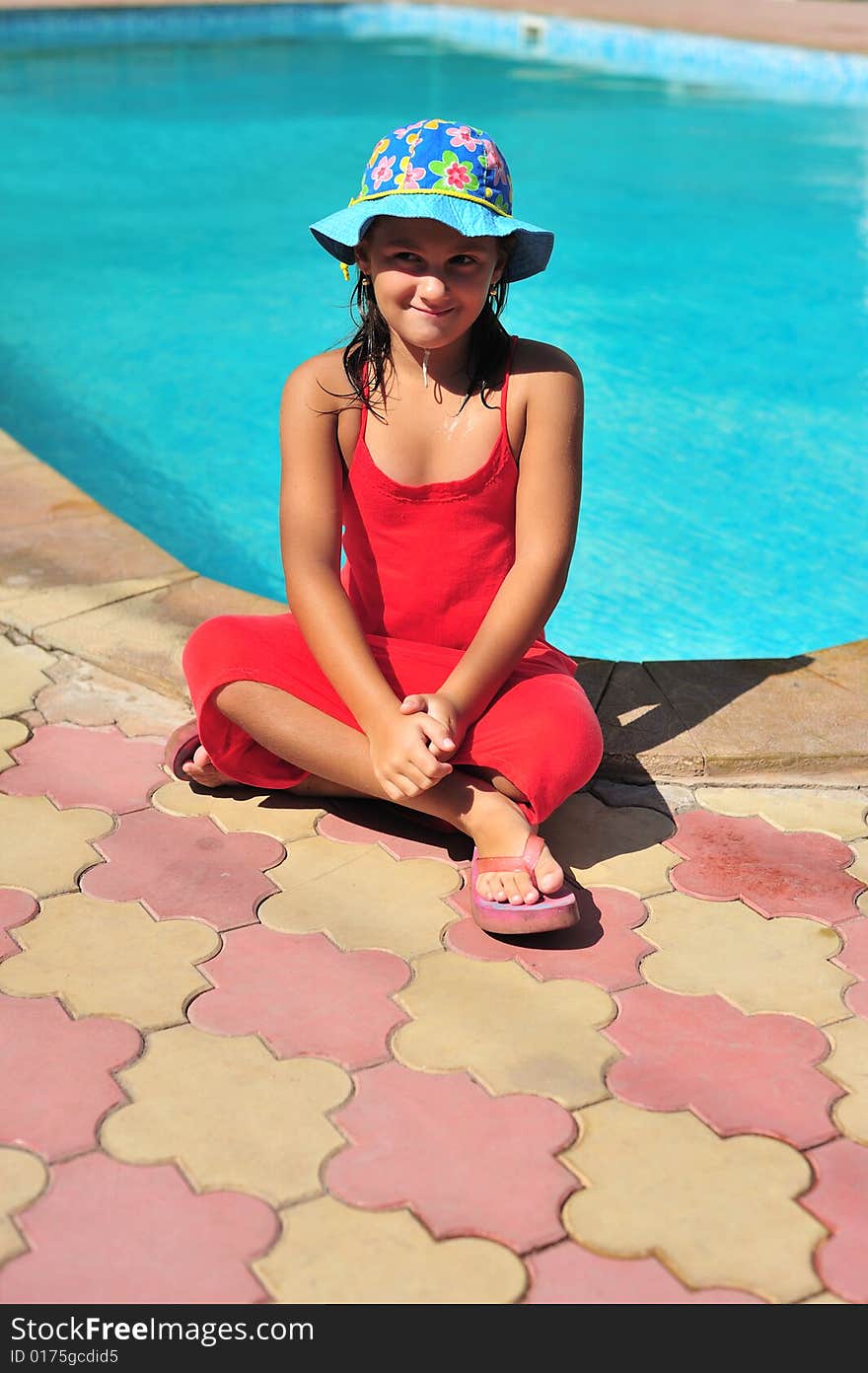 Young girl in red dress standing near pool. Young girl in red dress standing near pool