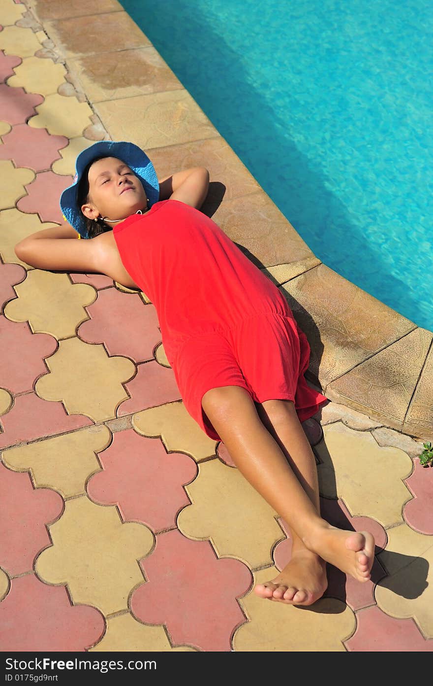 Young girl in red dress standing near pool. Young girl in red dress standing near pool