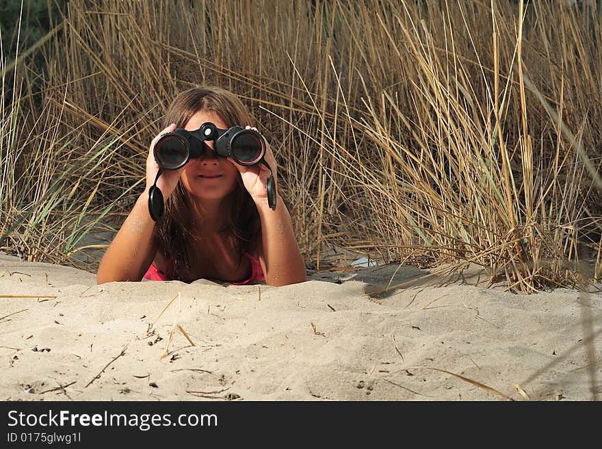 Young girl looking through binocular, low angle view. Young girl looking through binocular, low angle view