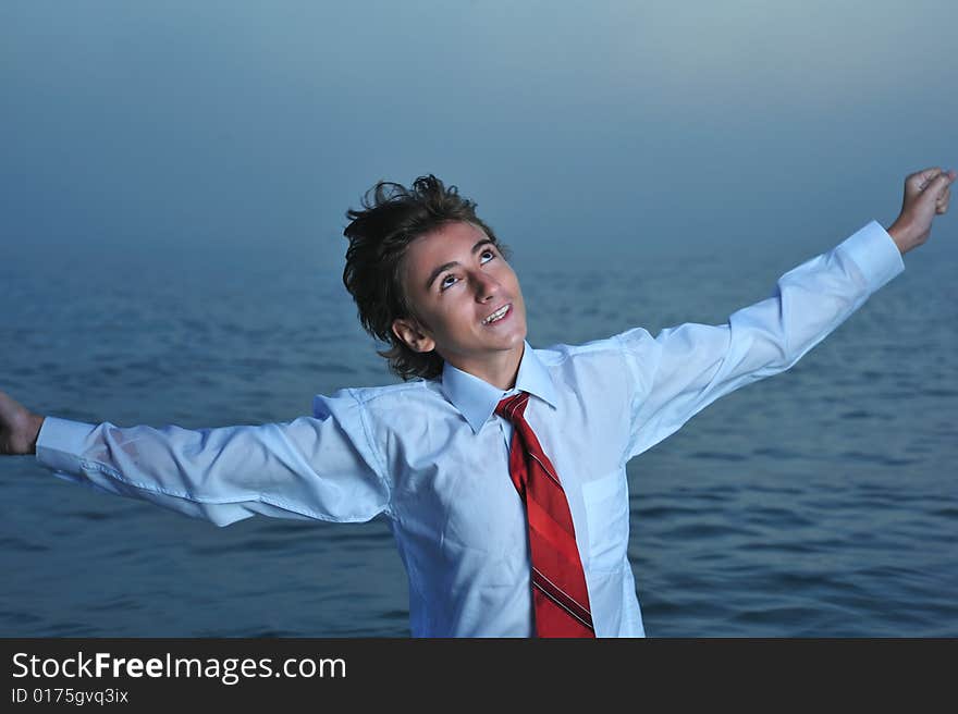 Young businessman standing on sea and looking up. Young businessman standing on sea and looking up