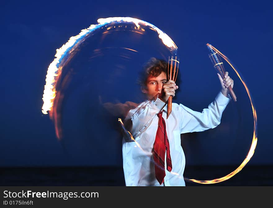 Young businessman handling flaming torch in night. Young businessman handling flaming torch in night