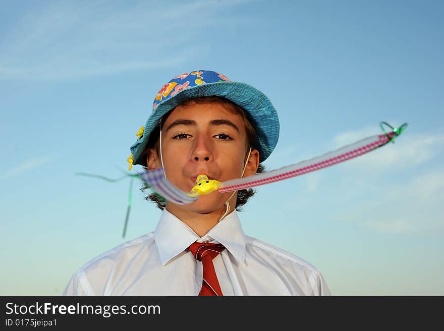 Young boy in shirt and tie blowing in blowers. Young boy in shirt and tie blowing in blowers