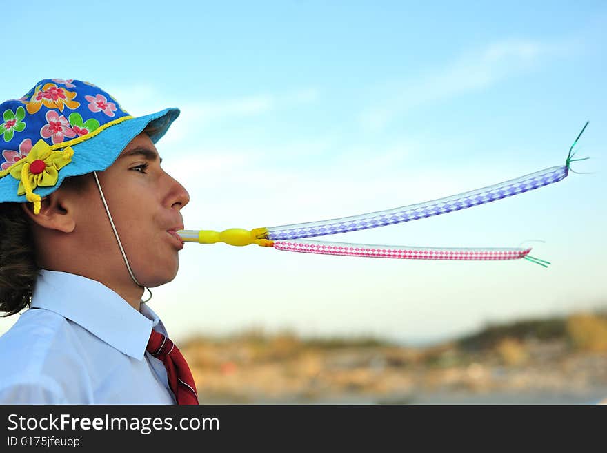 Young boy in shirt and tie blowing in blowers. Young boy in shirt and tie blowing in blowers