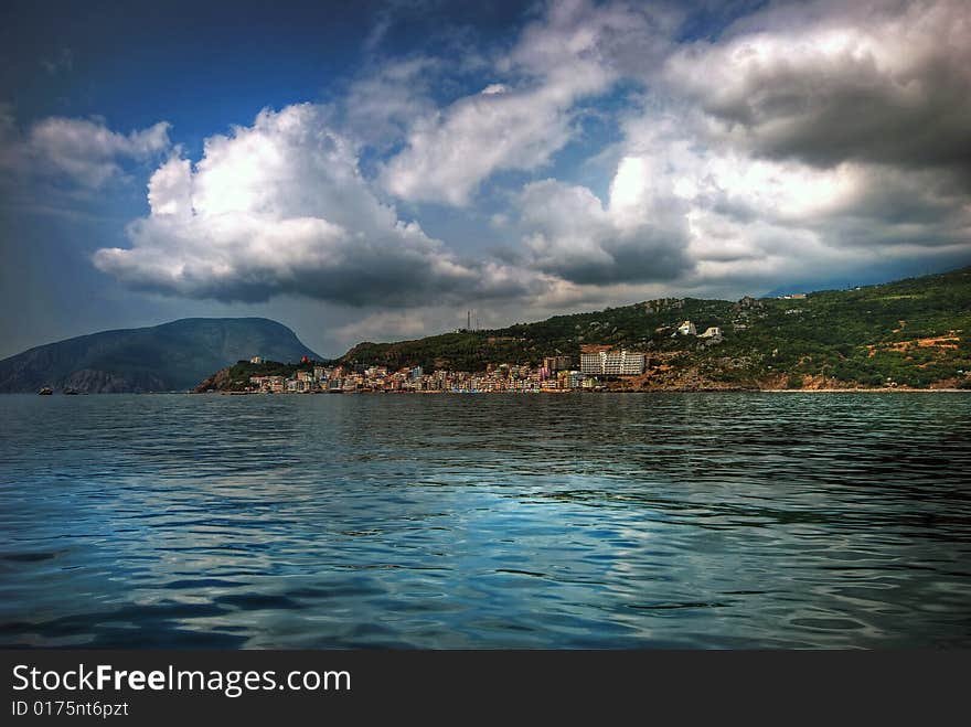 Type at sea with clouds on a background mountains