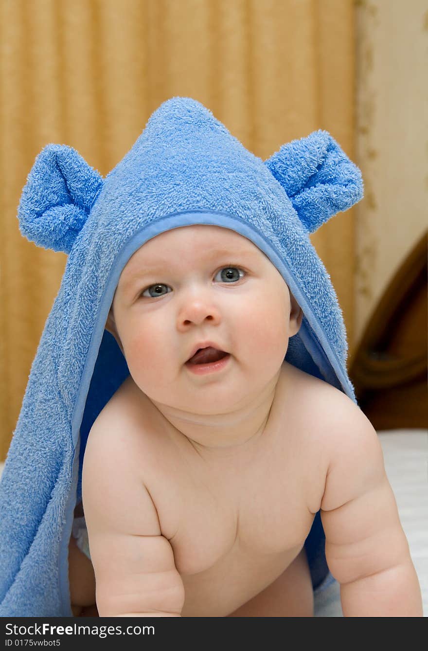 Small smiling baby in blue towel on bed #12