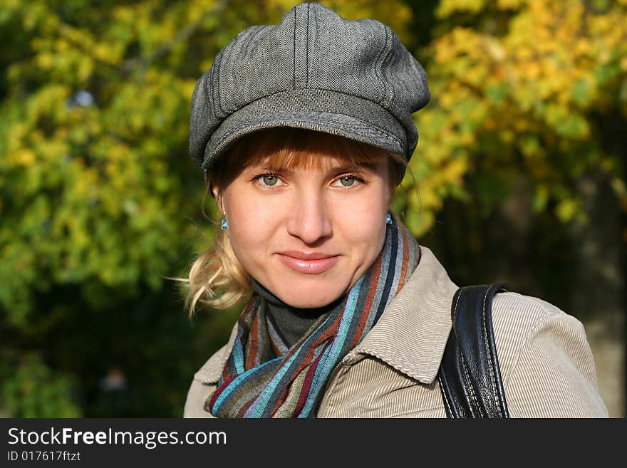 Beautiful blond  young woman in cap in autumn park. Beautiful blond  young woman in cap in autumn park