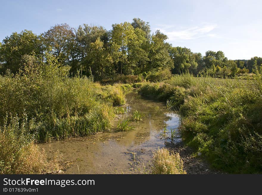 Typical landscape west of munich with meadows and creek in the light of late summer or beginning autumn. Typical landscape west of munich with meadows and creek in the light of late summer or beginning autumn