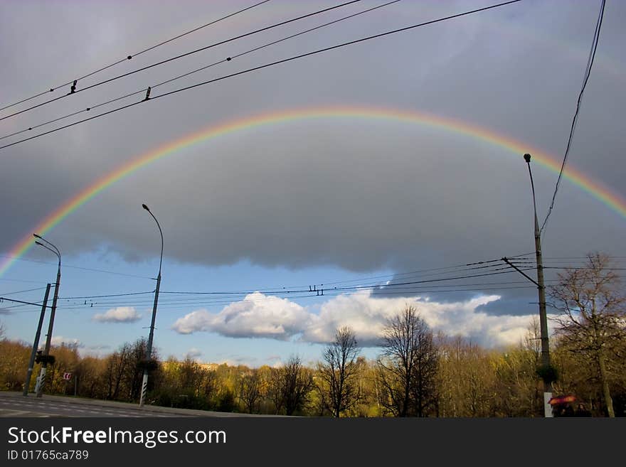 The cloudy sky and autumn rainbow above forest. The cloudy sky and autumn rainbow above forest.