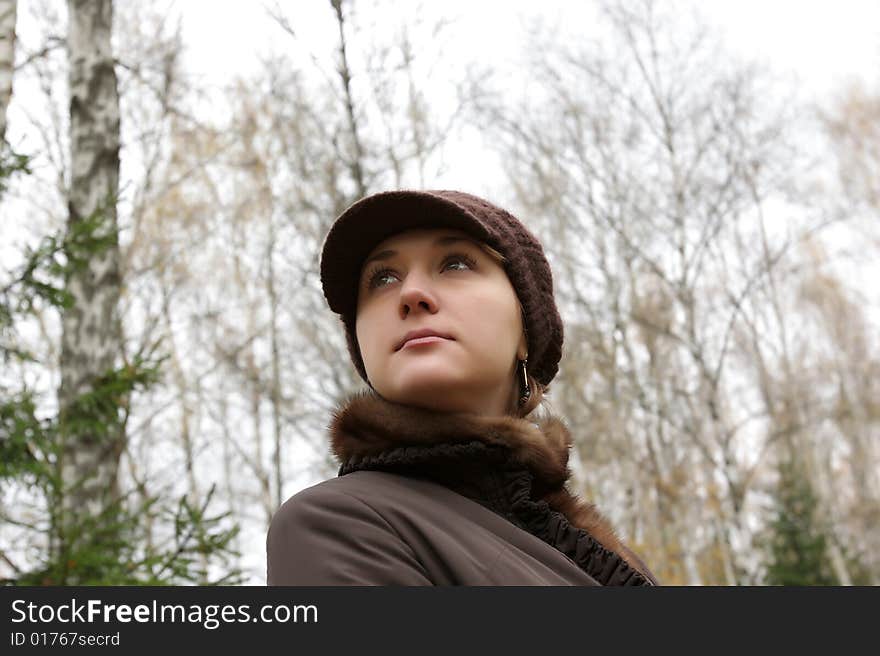 Autumnal portrait of young woman on trees background