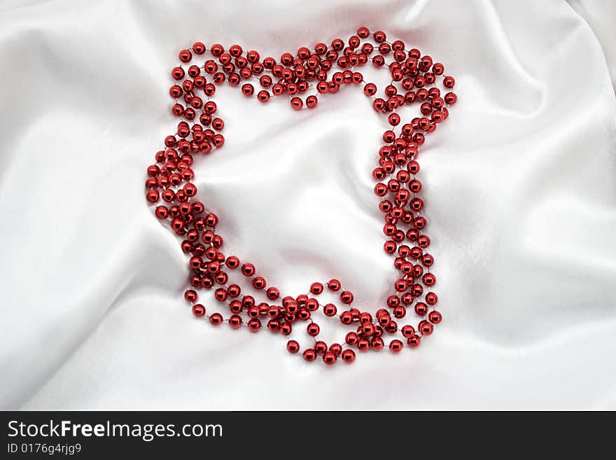 Red beads on white silk