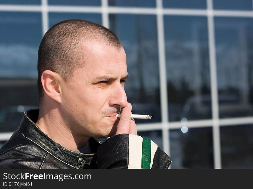 Man smoking outside on a business building background