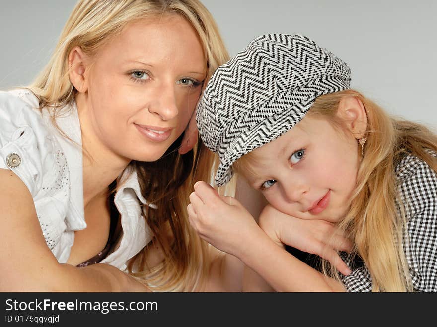 Cute happy blond mother & daughter wearing cap. Cute happy blond mother & daughter wearing cap