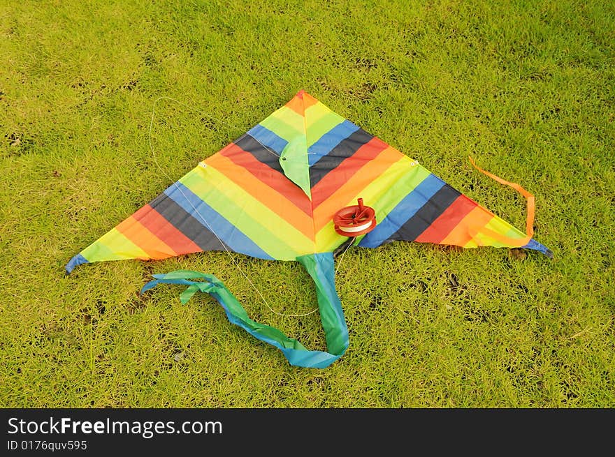 The colorful kite  lying on  the verdure spring meadow. The colorful kite  lying on  the verdure spring meadow.