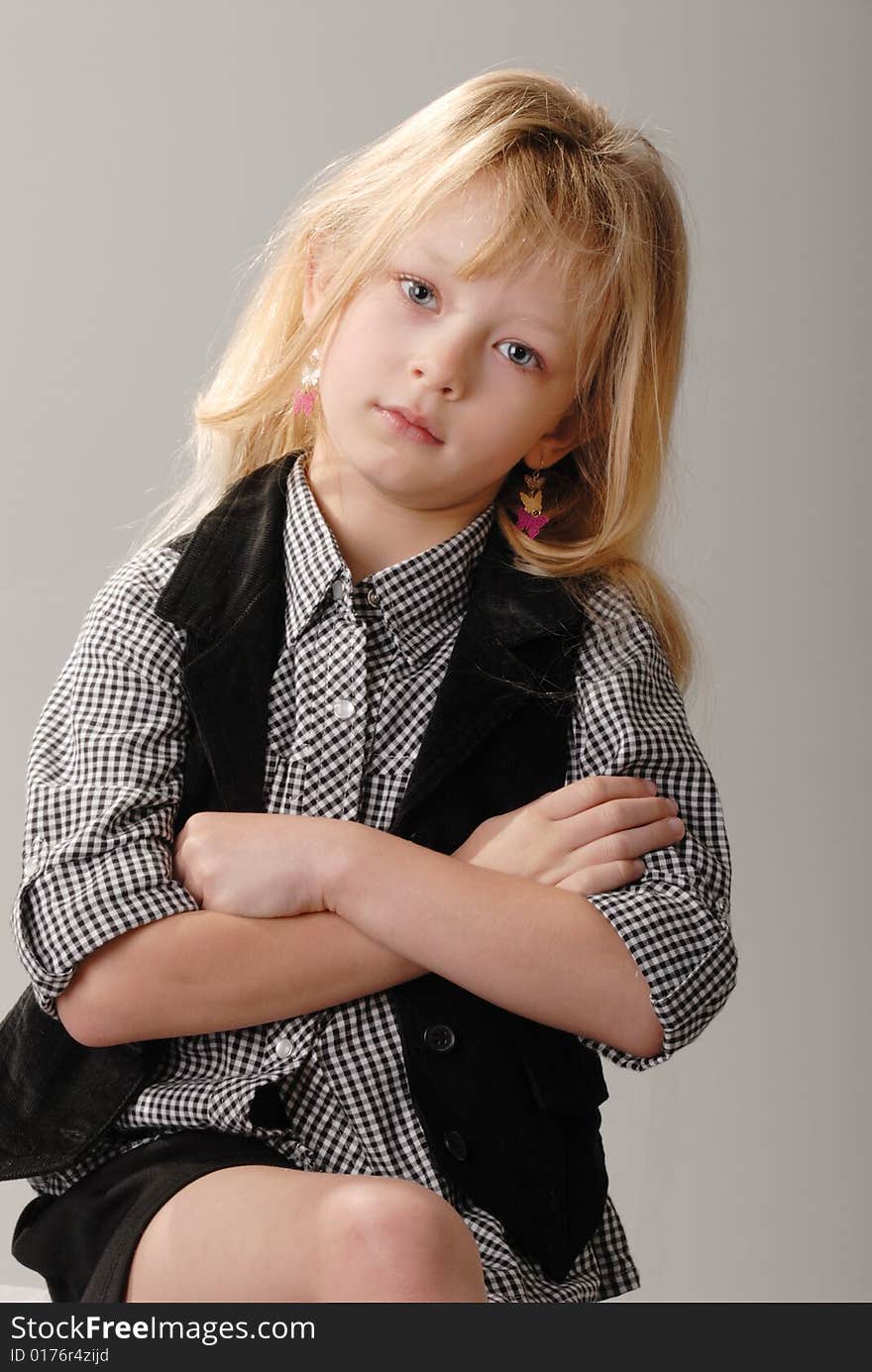 Cute little blond girl poses with serious expression