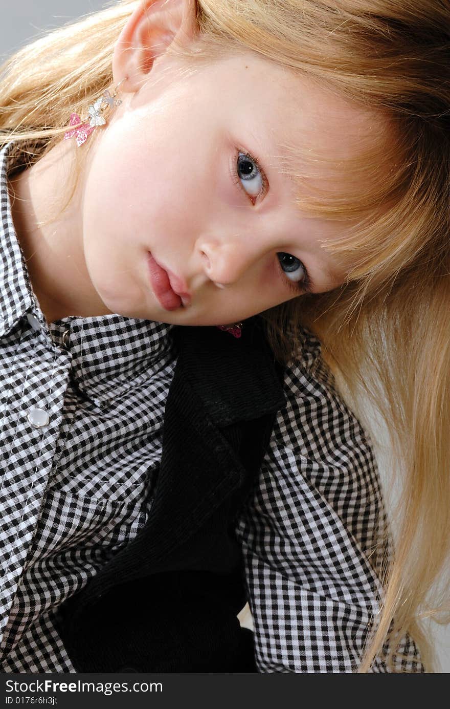 Cute little blond girl poses with serious expression