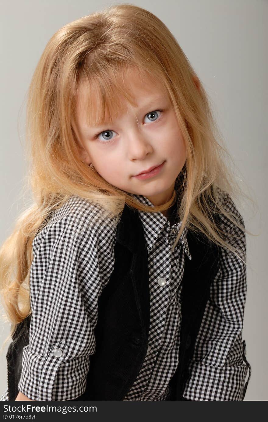 Cute little blond girl poses with serious expression