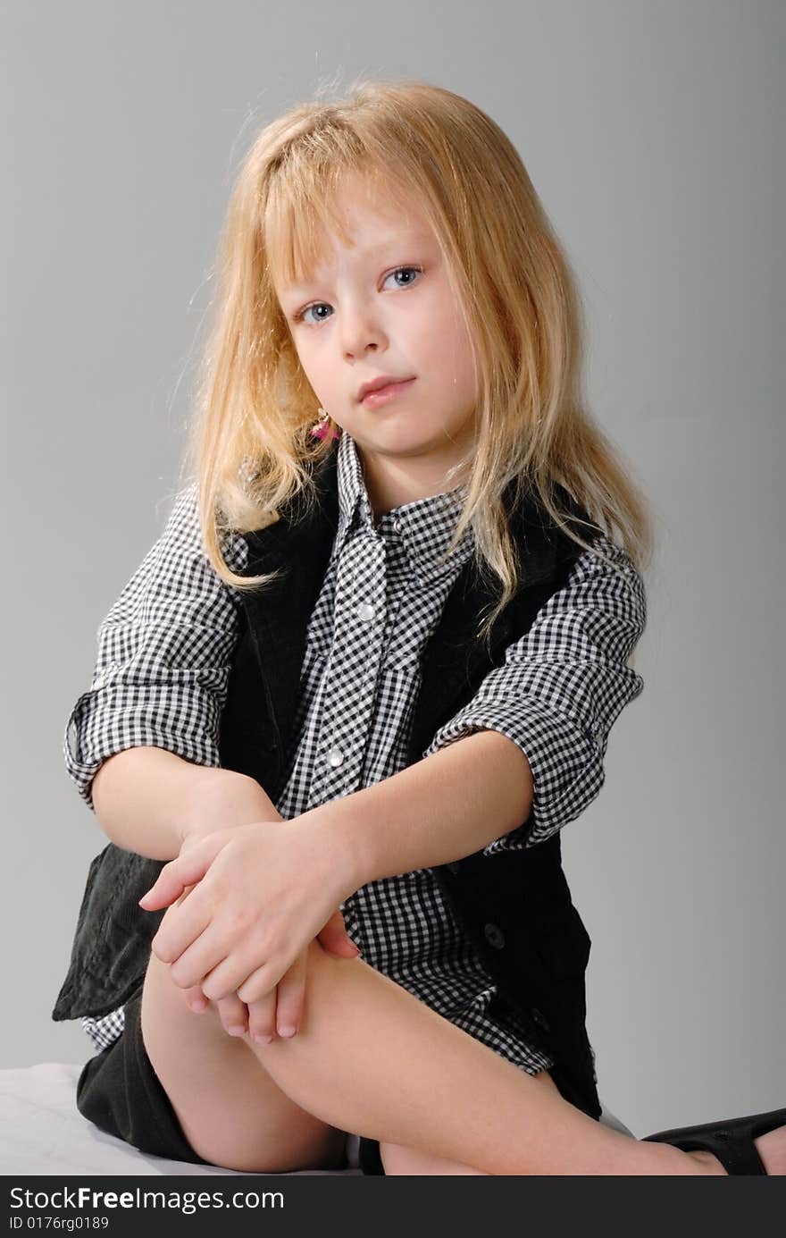 Cute little blond girl poses with serious expression