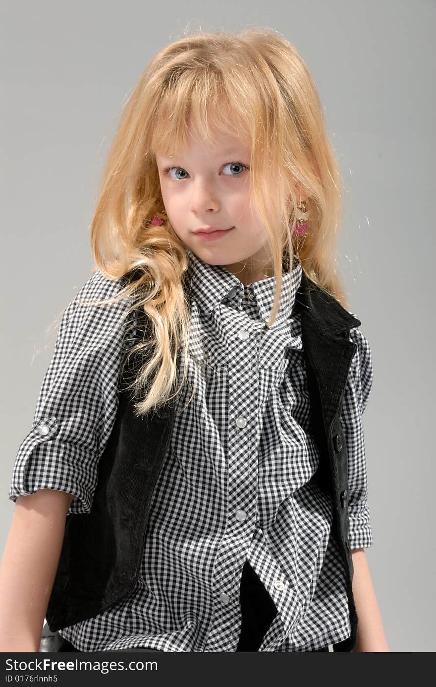 Cute little blond girl poses with serious expression