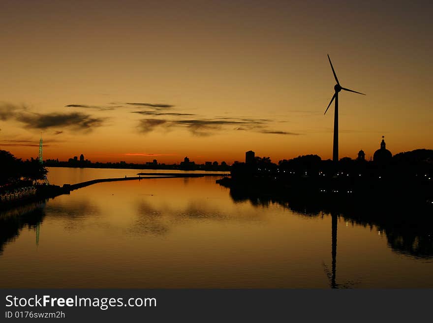 Sunset over water with windmill. Sunset over water with windmill