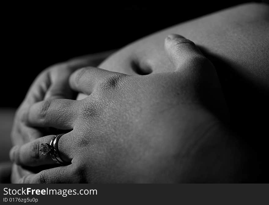 Pregnant woman holding her belly with both hands with view of wedding ring. Pregnant woman holding her belly with both hands with view of wedding ring