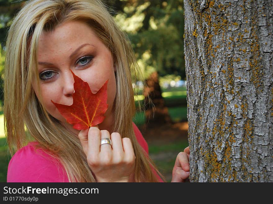 A beautiful woman holding a autumn leaf. A beautiful woman holding a autumn leaf