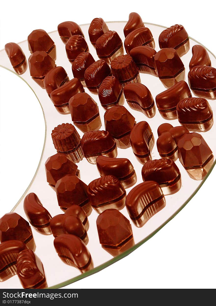 assorted chocolate candies on a dish isolated on white