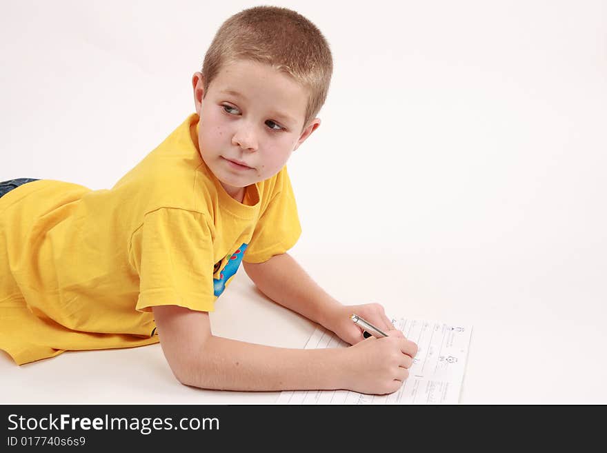 Young boy is writting in his exercise book with pen. Young boy is writting in his exercise book with pen