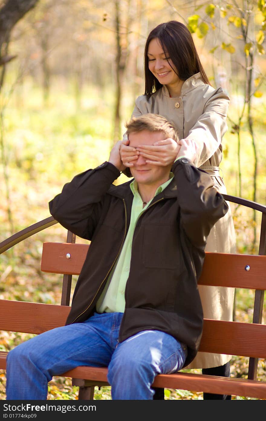 Young happy girl has closed its eyes a young man.  Focus point on girl face. Young happy girl has closed its eyes a young man.  Focus point on girl face