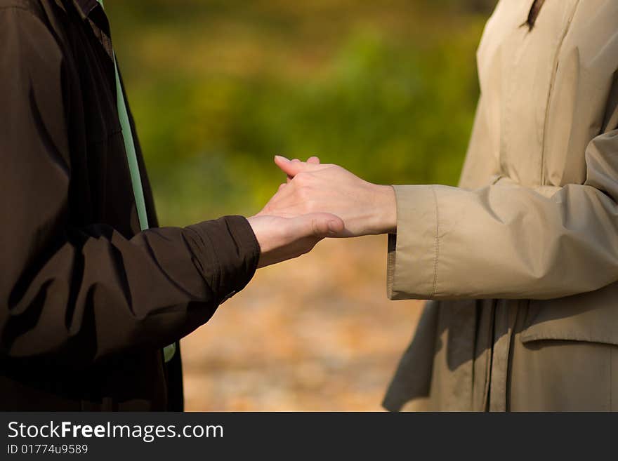 A young couple is holding hands in park